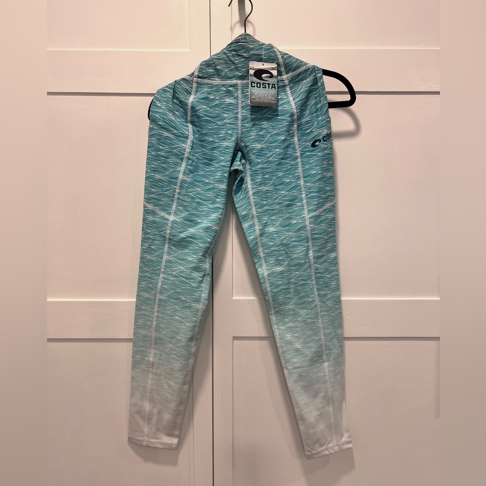 Costa leggings. 2 pockets. 1 zip pocket and 1 open side pocket with logo.